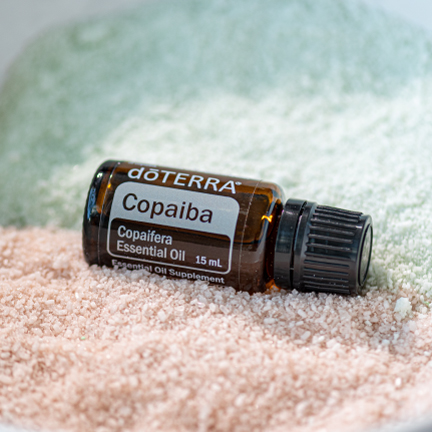 Bottle of Copaiba oil with bath salts. There are many uses for Copaiba essential oil, including soothing anxious feelings and supporting body systems.