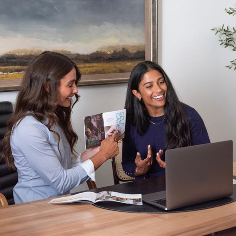 A man in front of a computer holding a doTERRA product.