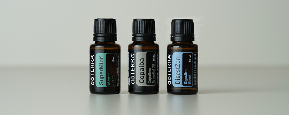 SuperMint, Copaiba, and DigestZen bottles standing next to each other with a white background.