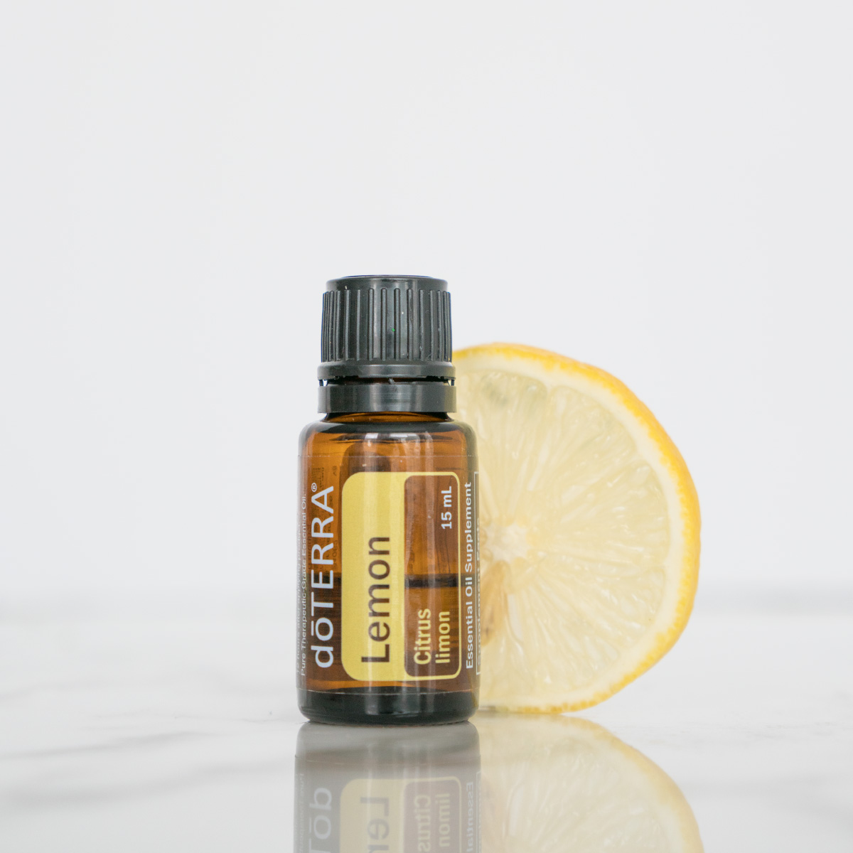 Bottle of Lemon oil next to fresh lemon slice. How can I use Lemon oil? Lemon essential oil can be used to clean surfaces around the home, to aid in digestion, and to uplift the mood.