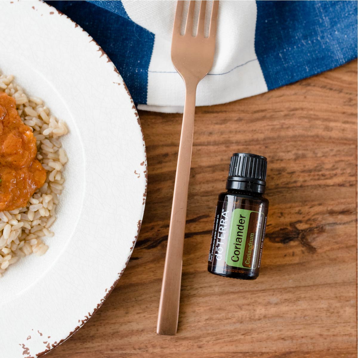 Bottle of Coriander oil next to fork and plate of food. What goes well with Coriander essential oil? Coriander oil blends well with essential oils like Peppermint oil and Wintergreen oil.