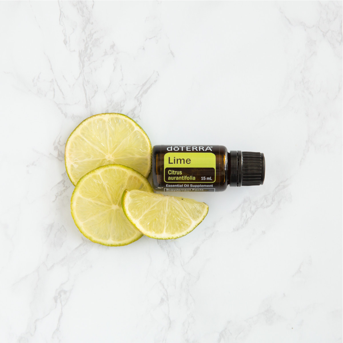 Lime essential oil bottle next to fresh lime slices. Why is Lime essential oil good for you? There are many health benefits of Lime oil, including benefits for immunity and respiratory health.