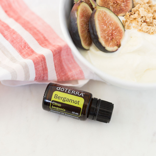 Bergamot oil bottle next to breakfast bowl of oats, yogurt, and figs. What are the benefits of bergamot oil? Bergamot essential oil is good for lessening tension and feelings of stress, creating a calming atmosphere for sleep, uplifting the mood, cleansing the skin, and more.