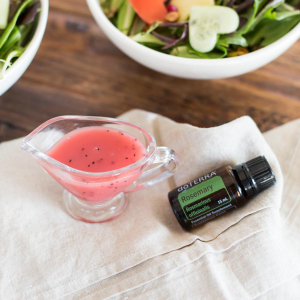 Bowl of salad, container of salad dressing, bottle of doTERRA Rosemary oil. There are many benefits of rosemary essential oil. Because of its powerful flavor, people love to use rosemary oil for cooking.
