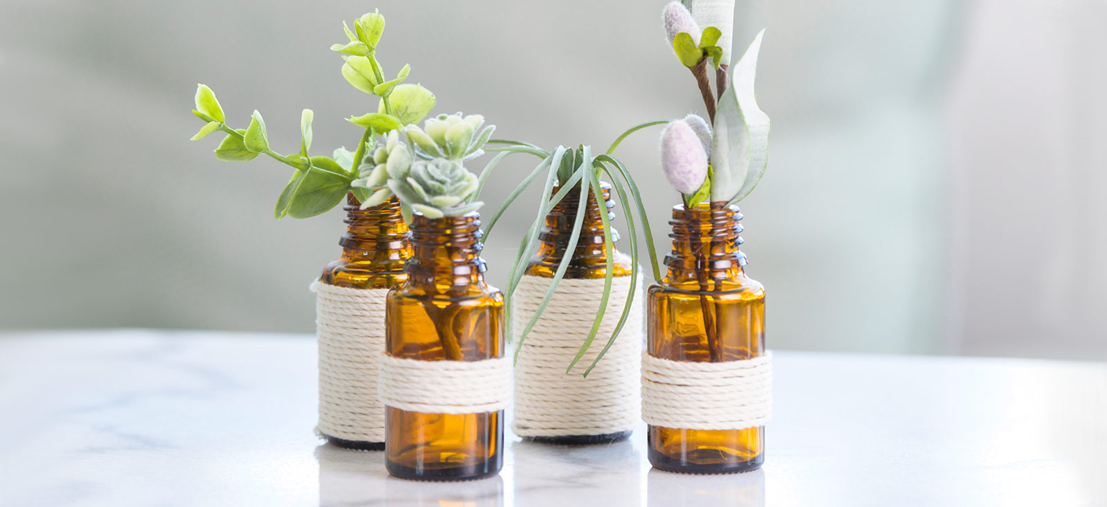 4 bottle of Essential Oils with plants on it