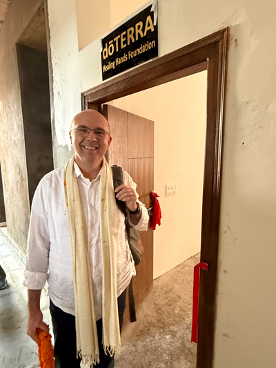 Dr. Russell Osgothorpe standing in a doorway where up above the door reads, doTERRA Healing Hands Foundation.