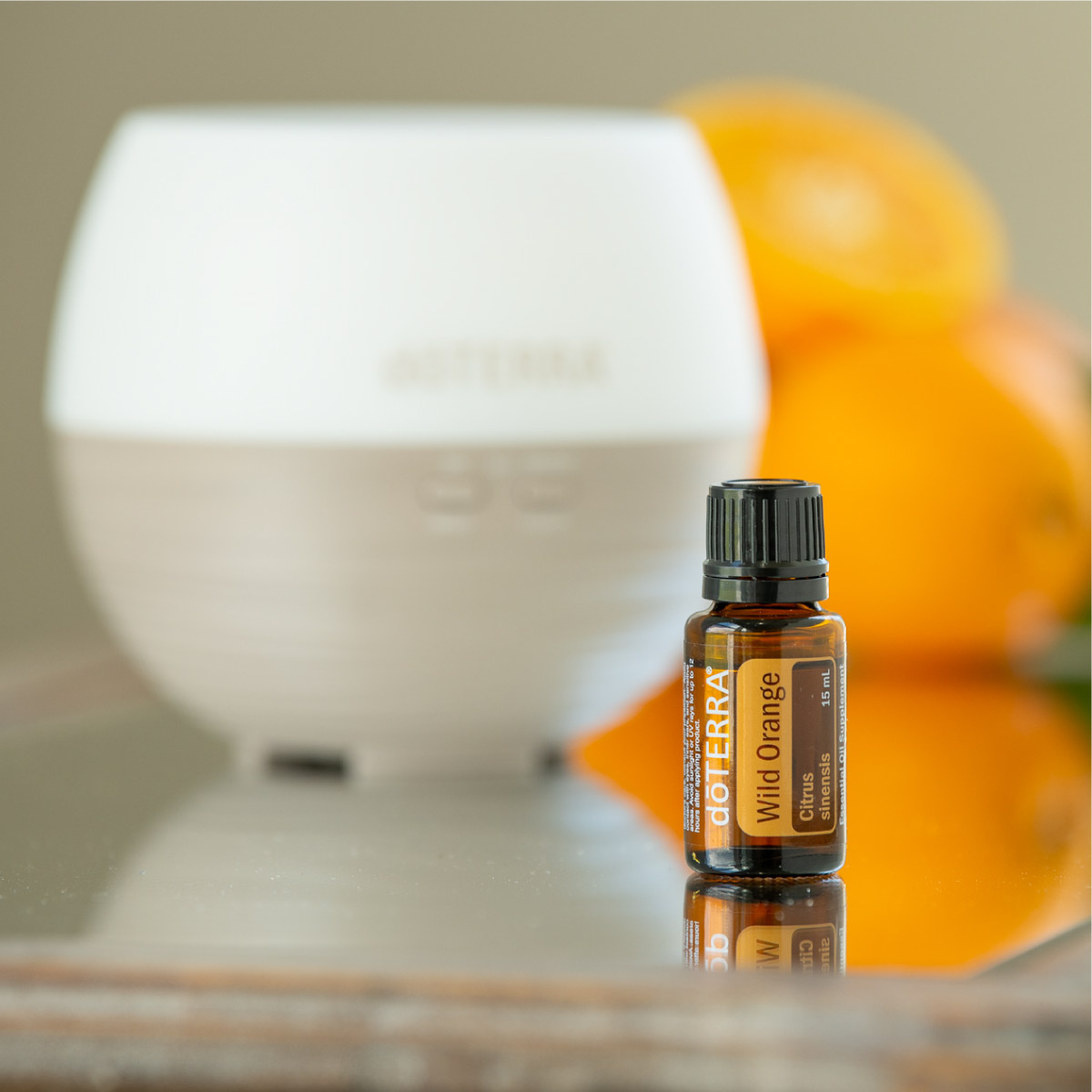Wild Orange Essential Oil in front of a diffuser