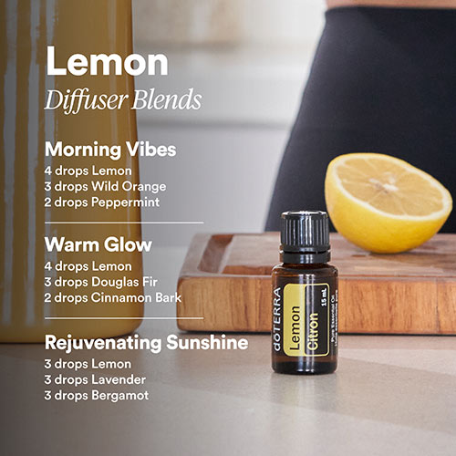 doTERRA Lemon essential oil sitting on the counter in front of a cutting board with half of a lemon on the board. The photo includes text of three Lemon diffuser blends.