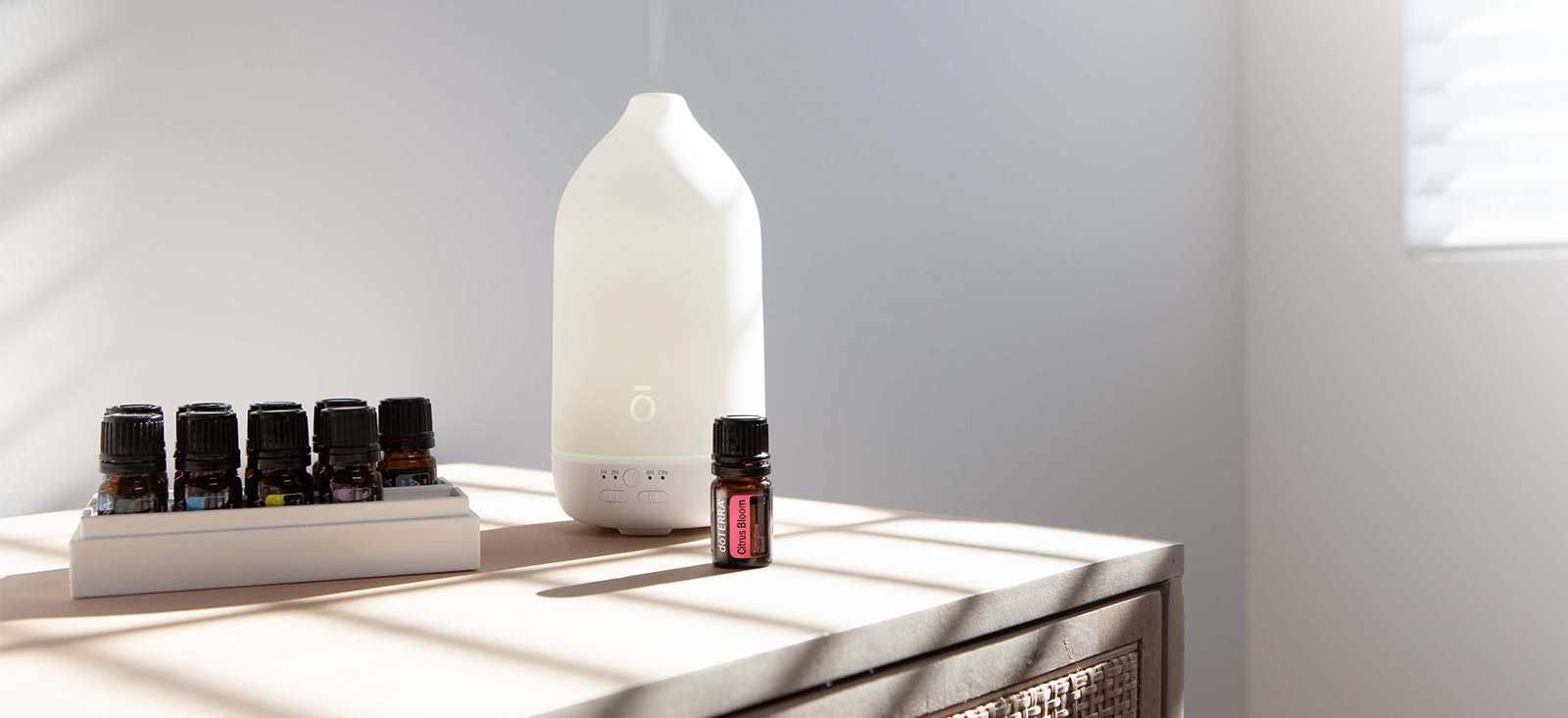 Laluz diffuser sits on a table next to doTERRA essential oils.