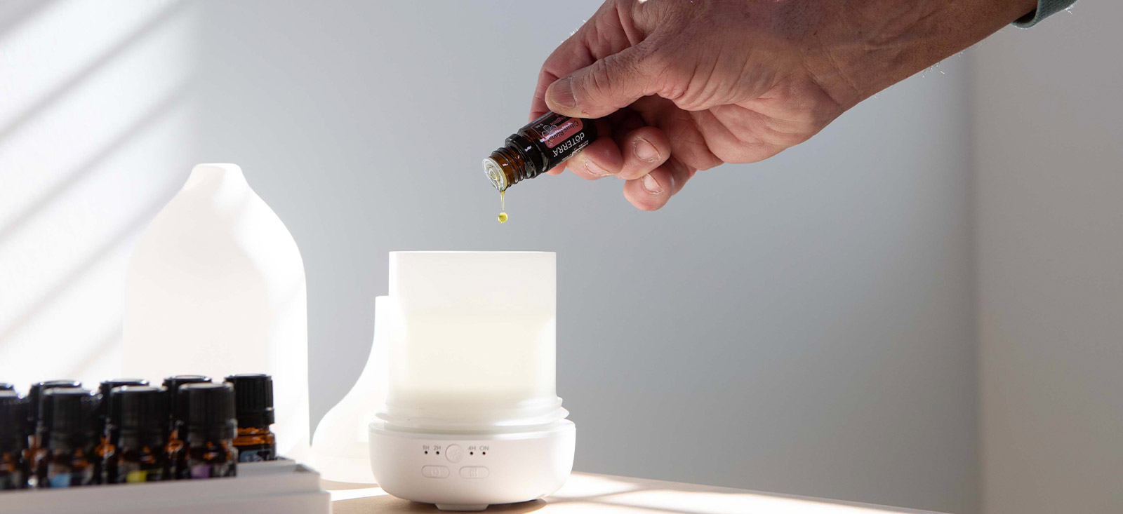 A person pouring essential oil into a diffuser