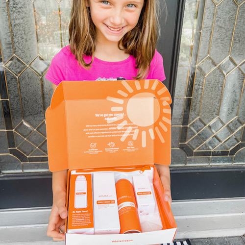 Girl holding a box with doTERRA sun Products