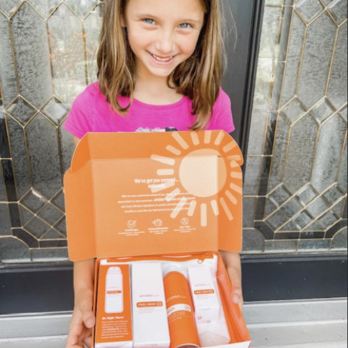 Girls holding a box with doTERRA sun Products