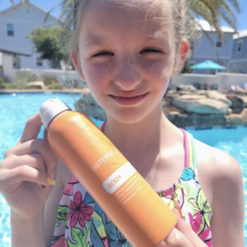 Girl holding doTERRA sun Body Spray