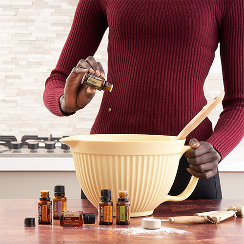 A woman making a recipe with essential oils in a bowl.