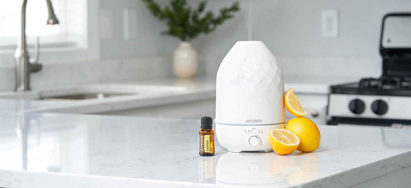 Lemon Essential Oil beside Volo Diffuser and some lemons