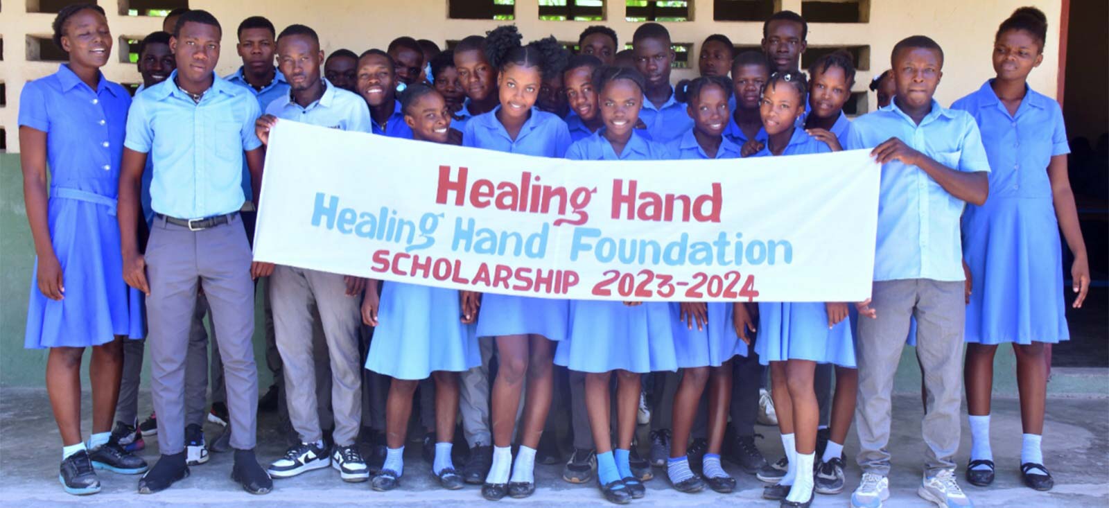 Group of students holding a banner saying Healing Hand Foundation Scholarship 2023-2024.