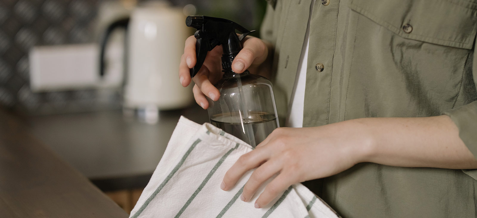 Man holding a spray and a cleaning cloth