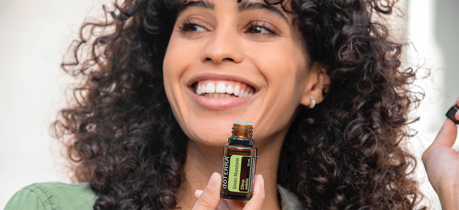 Woman holding Green Mandarin Essential Oil