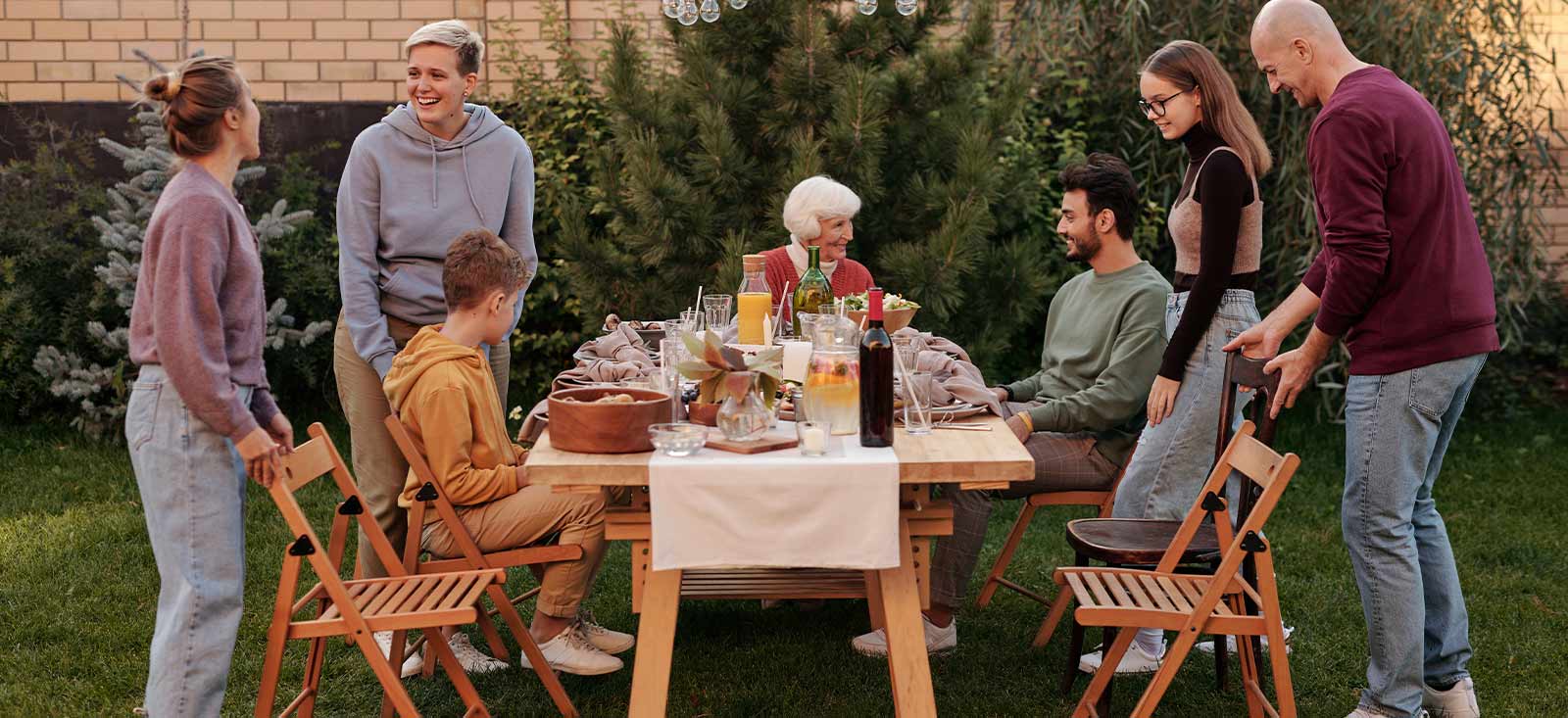 Family sitting around a table outside enjoying summer