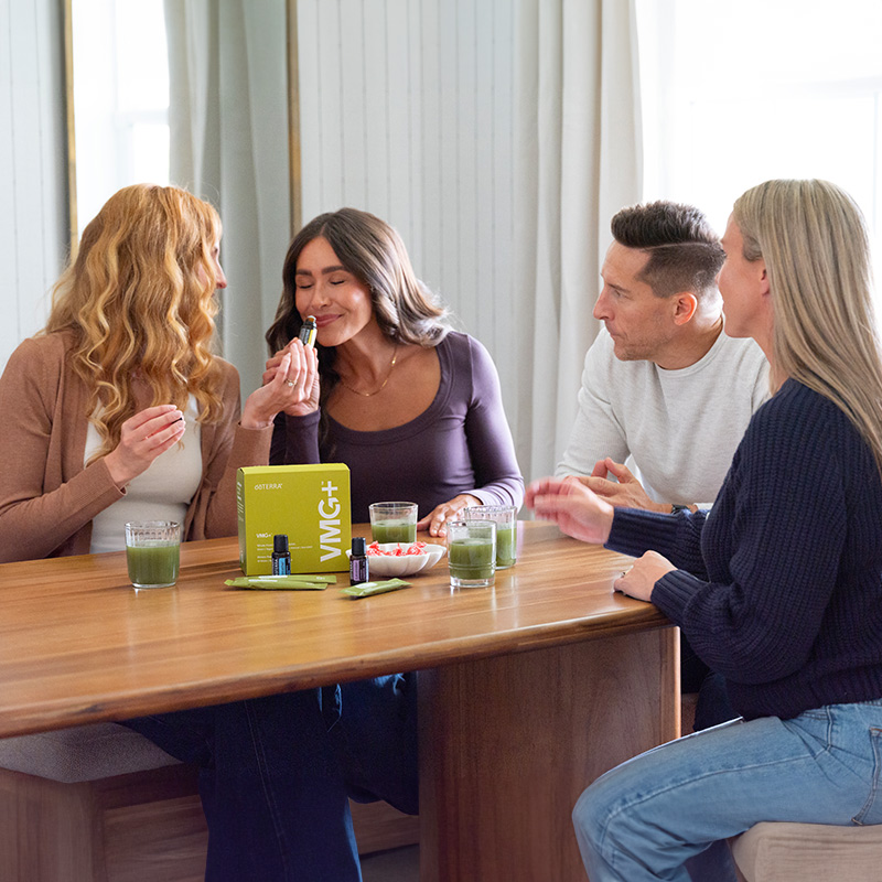 A group of people sitting around a table with VMG+ set on the table.
