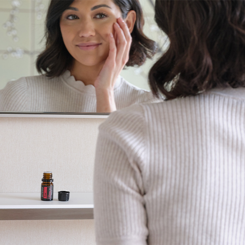 Woman using rose oil for facial skin care