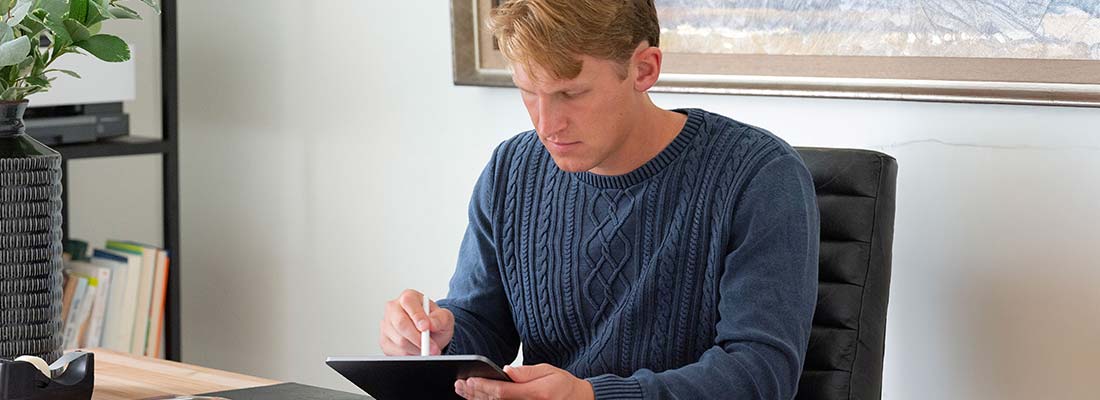 A man sitting at a table with a tablet