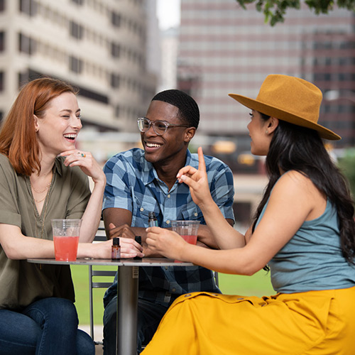 People chatting at a table in a park