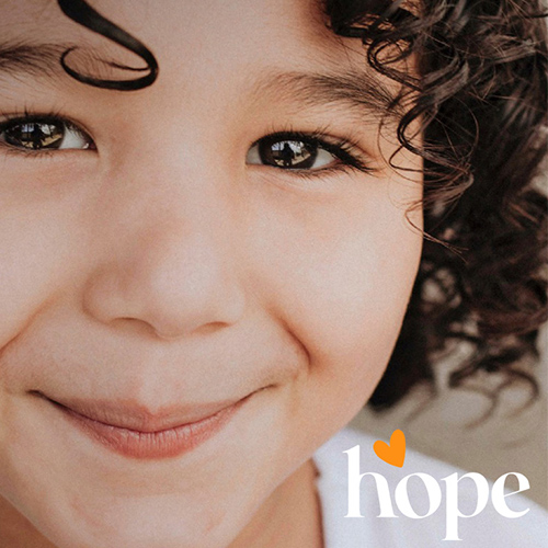A smiling child with the Hope logo