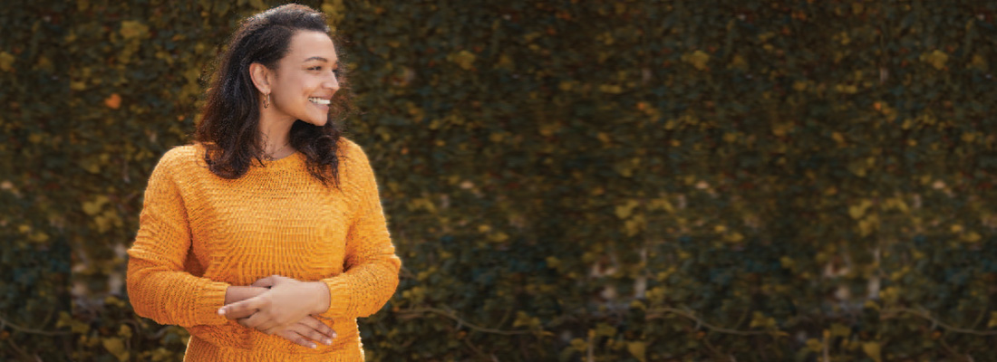 A woman in an orange sweater smiling