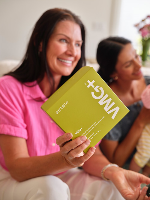 A woman smiling and holding a box of VMG