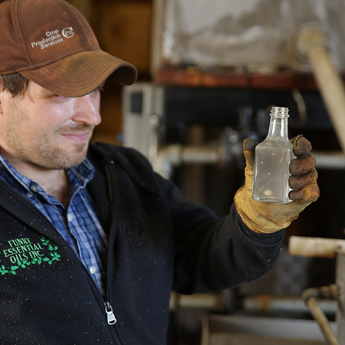 A man holding a jar of peppermint oil