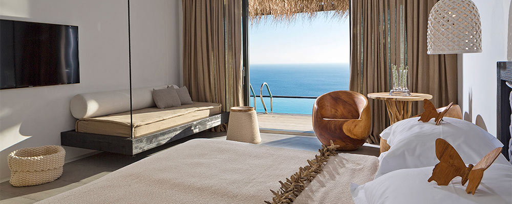 A bedroom with a tv and a view of the ocean