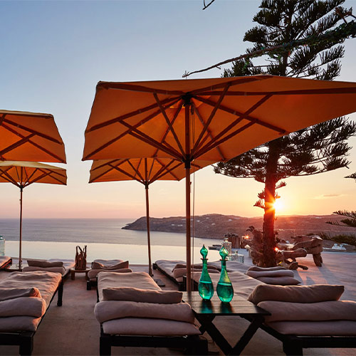 A group of lounge chairs with umbrellas overlooking the ocean