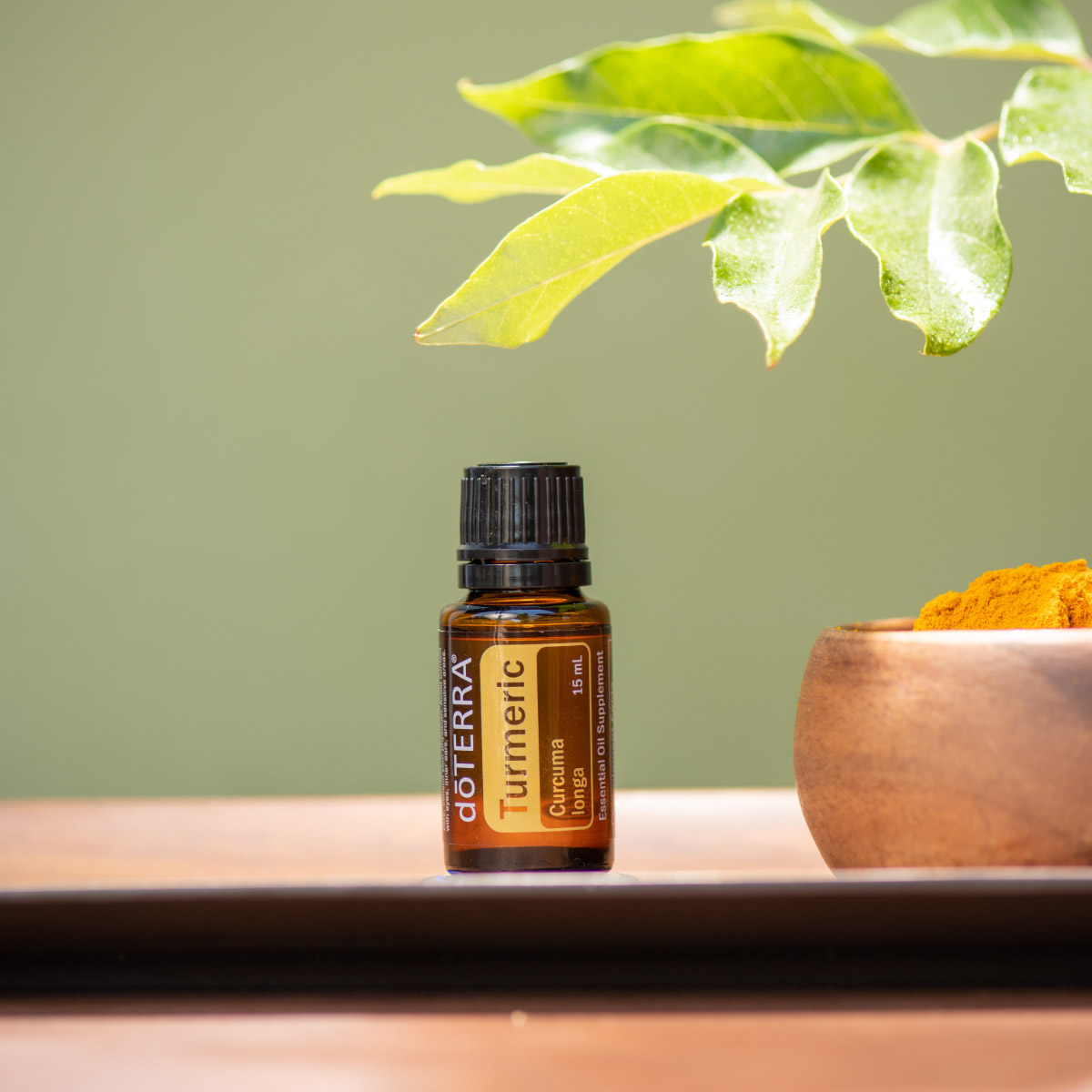 Bottle of Turmeric essential oil next to brass bowl and green leaf. What are the benefits of Turmeric oil? Turmeric oil has internal benefits for the nervous system and immune system, plus it holds benefits for the skin when applied topically.