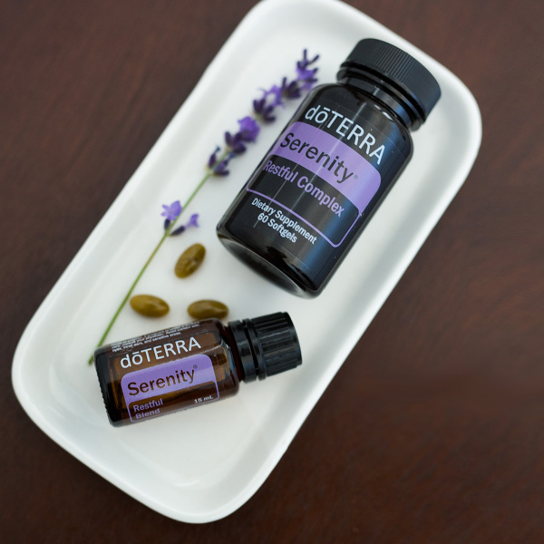 doTERRA Serenity Essential Oil and Softgel on a white tray with lavender flower